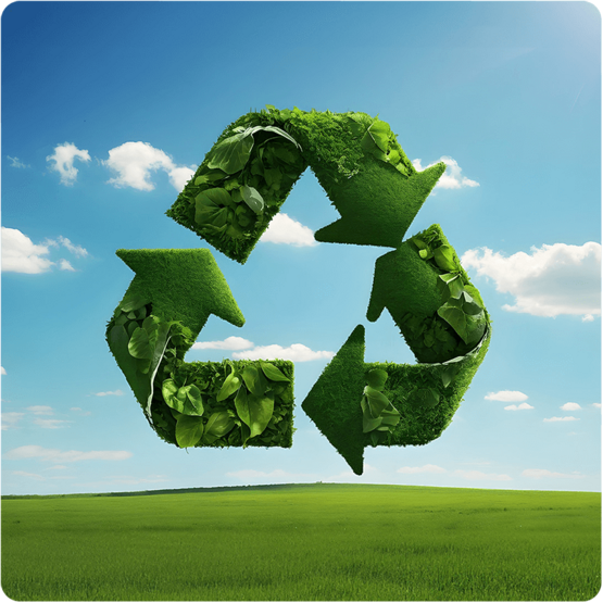 Ein grünes Recycling-Symbol, das aus Blättern besteht, vor einem klaren Himmel und einer grünen Wiese.